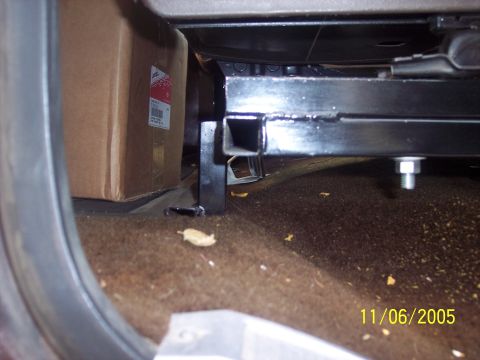 1976 Ford F-150 - A close-up view of a vehicle's seat bracket, with a cardboard box visible behind it.