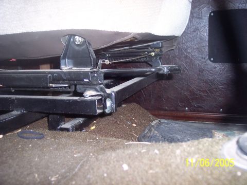 1976 Ford F-150 - The underside of a vehicle seat shows its metal brackets and adjustment mechanism.