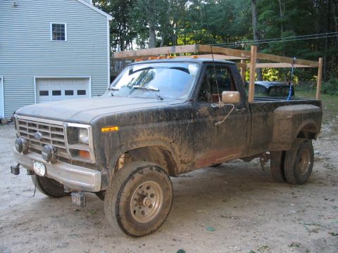 1985 Ford F-350 - This black Ford F-350 dually pickup truck has a wooden rack installed over the bed.