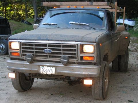 1985 Ford F-350 - This 1980s Ford F-350 dually truck is covered in dust and has a wooden rack mounted above the cab.