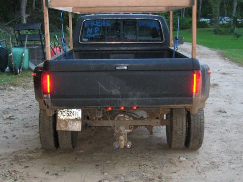 1985 Ford F-350 - This Ford F-Series truck has a dual rear wheel setup and a wooden rack structure installed in the bed.