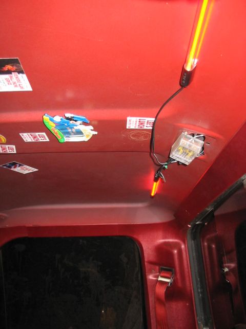 1985 Ford F-350 - Interior view of a red vehicle's headliner, adorned with stickers and aftermarket lighting.