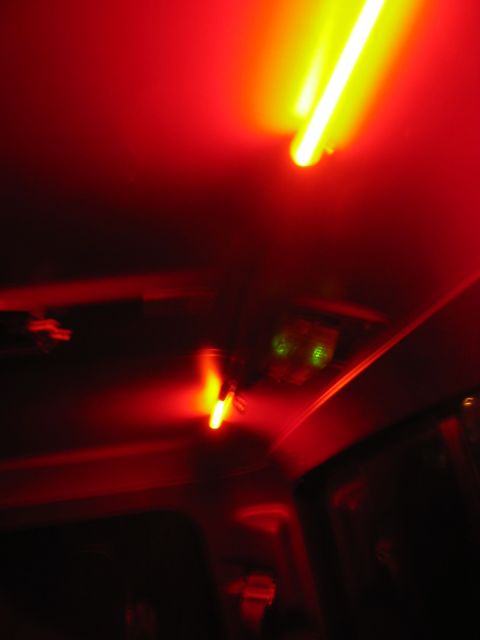 1985 Ford F-350 - The interior of a vehicle is illuminated by red lights, with some green lights visible on the dashboard.