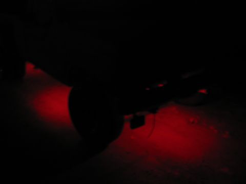 1985 Ford F-350 - Red underglow lighting illuminates the underside of a vehicle in the dark.