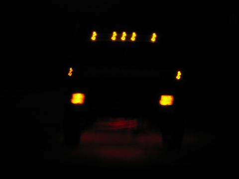 1985 Ford F-350 - Rear view of a 1985 Ford F-350 at night, showing illuminated brake and marker lights.