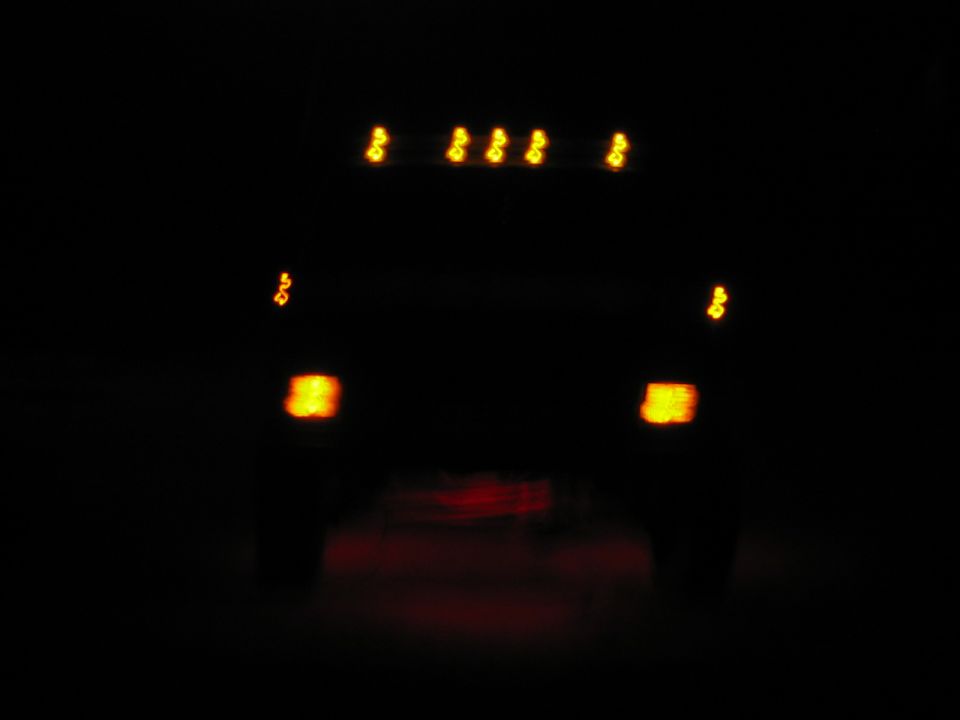 1985 Ford F-350 rear view with brake lights and cab marker lights illuminated at night