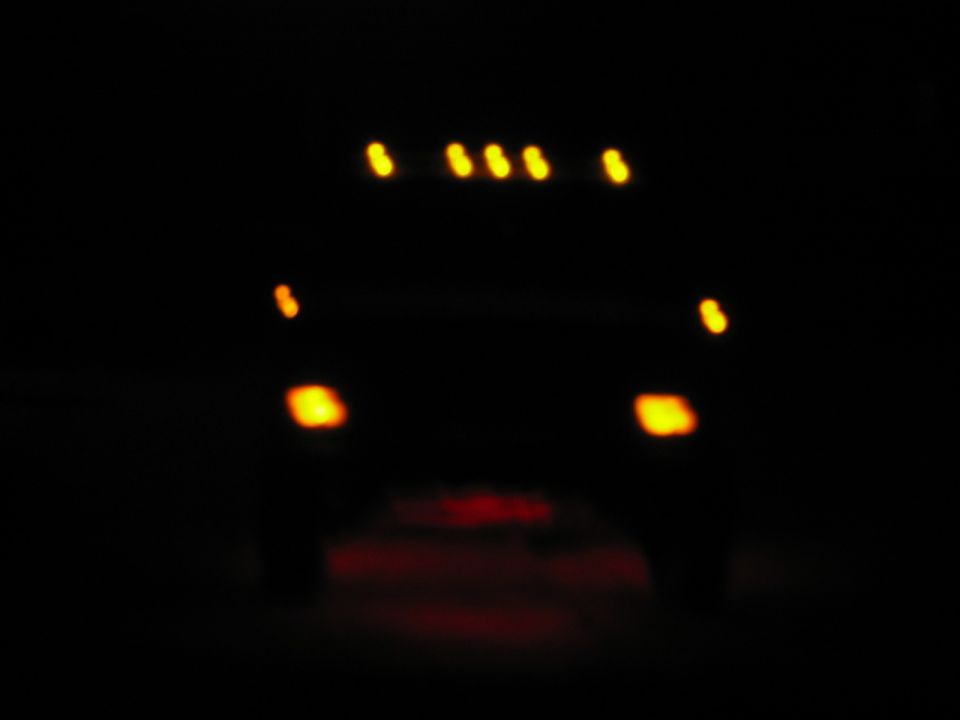 Truck at night showing amber cab roof clearance lights and rear marker lamps in the dark