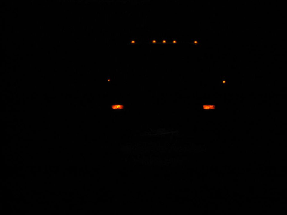 Truck front at night with amber marker lights illuminated on the roof and above the headlights