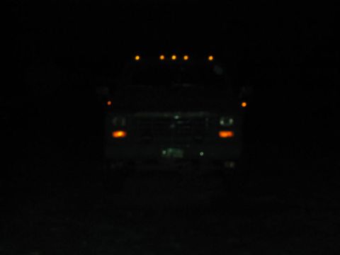 1985 Ford F-350 - A 1985 Ford F-350 is seen from the front at night, its roof marker lights glowing.