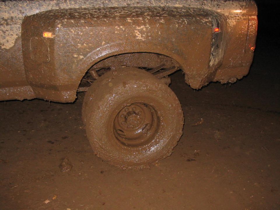 Mud-covered rear wheel and fender of a truck