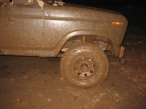1985 Ford F-350 - This truck is heavily covered in mud, suggesting it has been driven off-road or through difficult terrain.