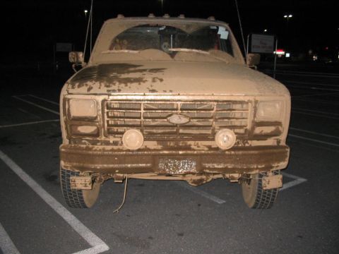 1985 Ford F-350 - This truck is heavily covered in mud, obscuring details like the license plate and making precise year identification difficult.