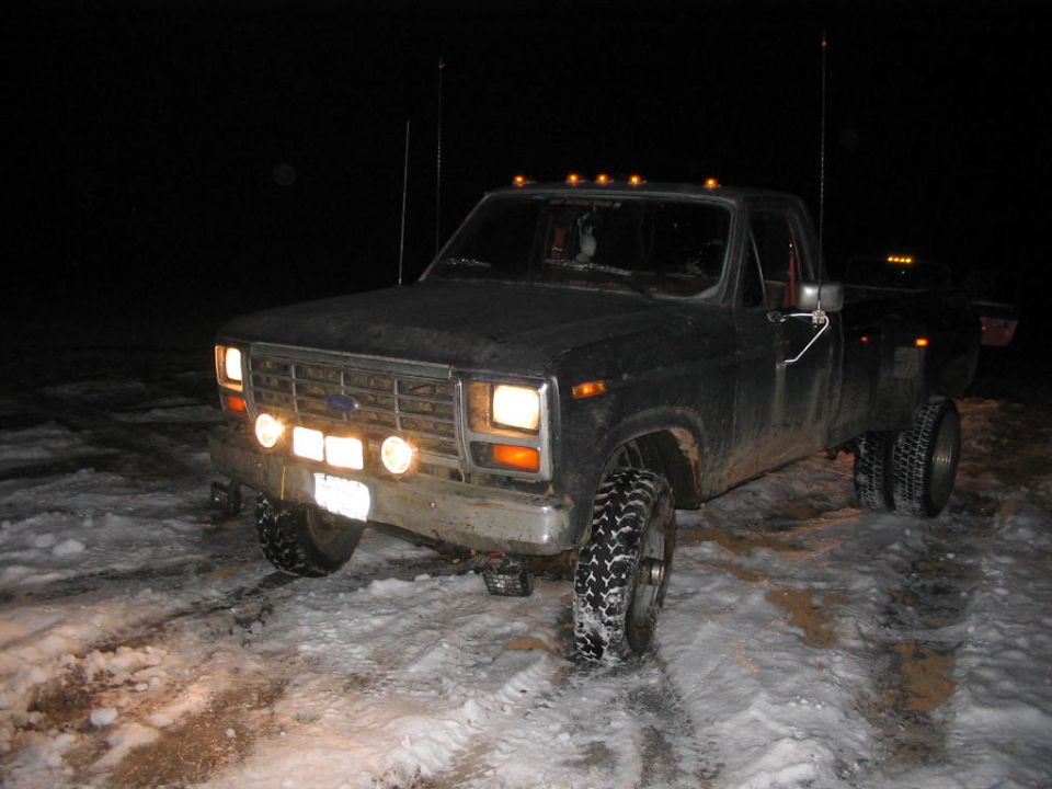 Ford F-Series truck with dual rear wheels in snow at night