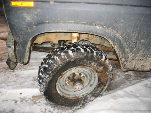 1985 Ford F-350 - Close-up of a muddy truck wheel and fender in a snowy environment.