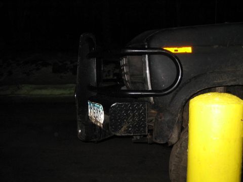 1985 Ford F-350 - A dark Ford F-Series truck is parked at night, showing its front bumper and grille.