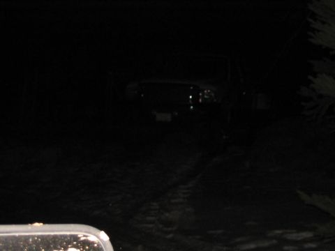 1985 Ford F-350 - A truck is seen at night with its headlights illuminated, casting a glow on the dark surroundings.