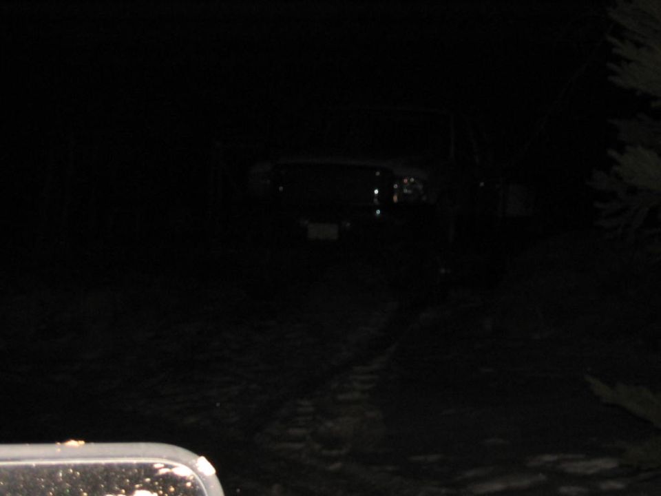 Dark front view of a truck with headlights on