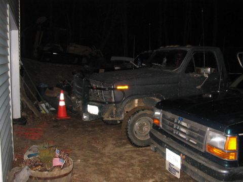 1985 Ford F-350 - Two Ford pickup trucks are parked outside at night, one appears to be an older F-series model.
