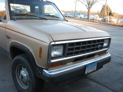 1988 Ford Ranger - The front end of a tan 1988 Ford Ranger pickup truck is shown parked on a street.
