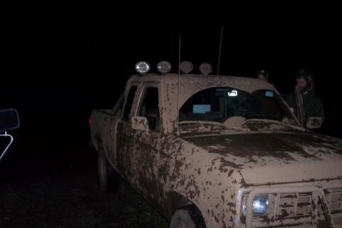 1988 Ford Ranger - A pickup truck is covered in mud after an off-road excursion at night.