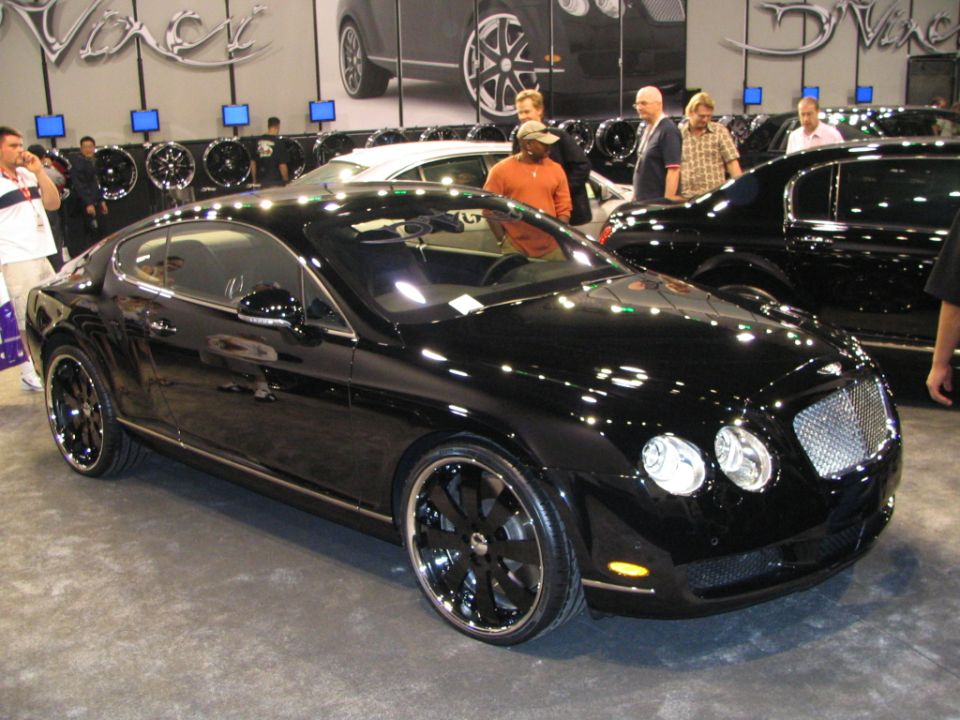 Black Bentley Continental GT coupe with aftermarket wheels at an auto show