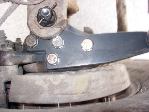1987 Ford Bronco - This is a close-up view of a vehicle's steering knuckle and tie rod assembly, showing the bolted components.