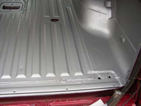 1995 Ford Bronco - The interior floor of a vehicle shows a metallic coating with visible seams and structural reinforcements.