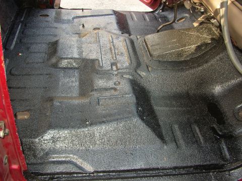 1995 Ford Bronco - The interior floor of a vehicle has been coated with a black spray-on liner, likely for protection and sound dampening.
