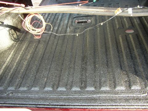 1995 Ford Bronco - Truck bed interior with black spray-on bedliner and coiled wires.