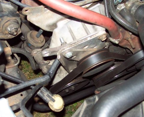 1985 Ford Crown Victoria LTD - Close-up view of the serpentine belt and pulleys in a vehicle's engine bay.