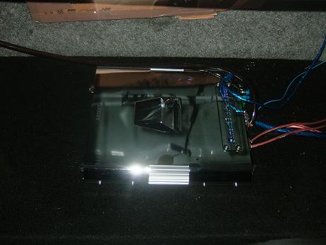 1992 Ford Crown Victoria - Car amplifier with visible wiring is shown in detail, resting on a dark carpeted surface.