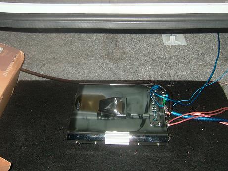 1992 Ford Crown Victoria - A car amplifier and its wiring are installed in the trunk of a vehicle.