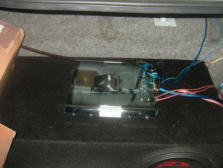 1992 Ford Crown Victoria - Car amplifier and wiring are visible in the trunk of a vehicle, connected to a subwoofer box.