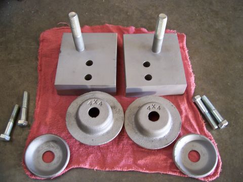 1983 Ford Bronco - TTB spring adapter blocks and hardware are laid out on a red cloth.