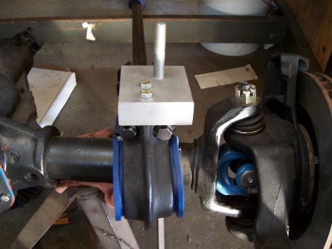 1983 Ford Bronco - Close-up of a vehicle's front axle suspension components with an installed adapter block.