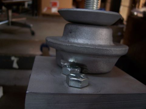 1983 Ford Bronco - A close-up shot focuses on a metal part, likely from a vehicle's suspension system, secured with bolts.