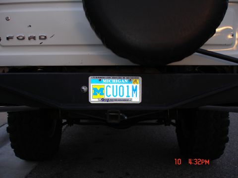 1979 Ford Bronco - The rear of a white Ford Bronco shows a Michigan license plate and a spare tire.