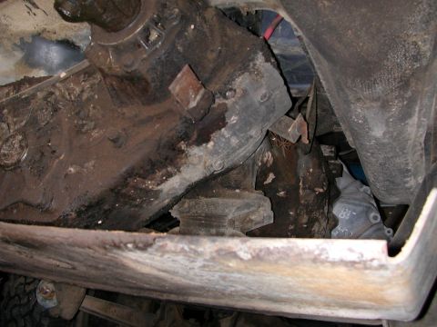 1992 Ford F-150 - The undercarriage of a vehicle, with visible rust and mechanical parts, is shown from a low angle.