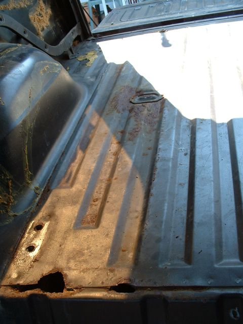 1978 Ford Bronco - The cargo area floor shows significant rust damage and wear, with visible holes in the metal.