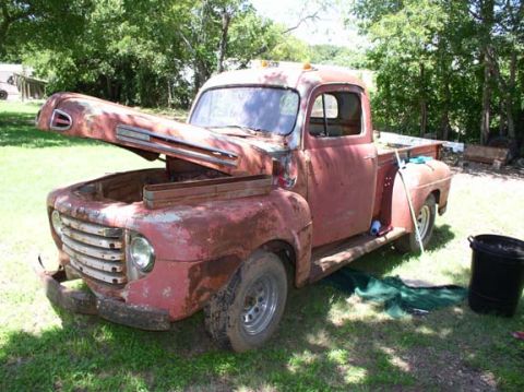 1978 Ford Bronco - This heavily rusted pickup truck is parked outdoors on a grassy area.
