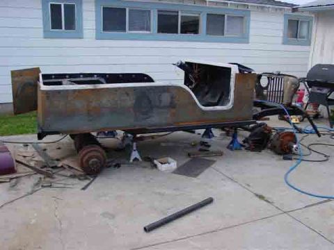 1976 Jeep CJ7 - The body of a Jeep CJ is shown undergoing restoration, with the chassis and drivetrain components visible nearby.