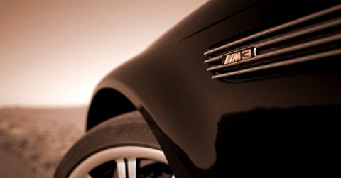 1996 Ford Probe - Close-up of a black car's fender, highlighting the M3 badge and chrome grille detail.