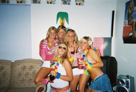 1985 Ford F-150 - A group of friends dressed in festive attire gather for a picture, holding drinks and wearing leis.