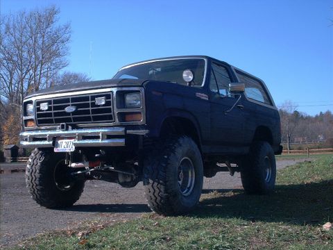 1986 Ford Bronco - This lifted Ford Bronco features a custom grille and bumper, with a visible license plate.