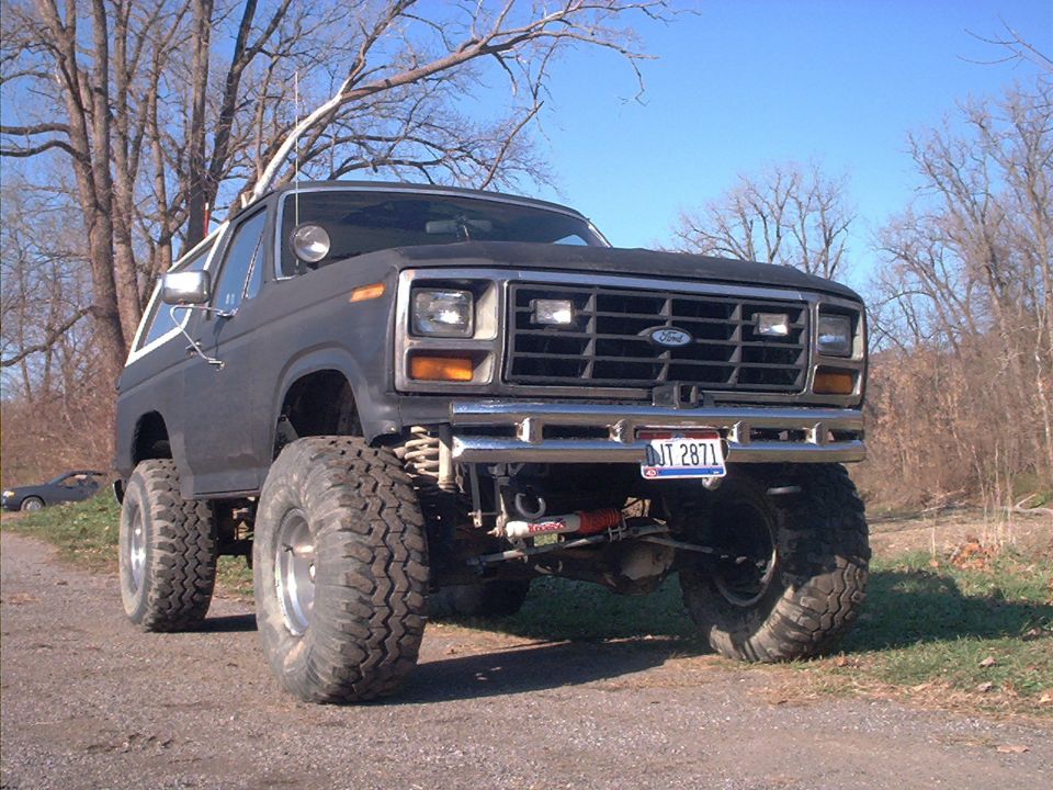Dark gray Ford Bronco with lifted suspension and large tires, front view