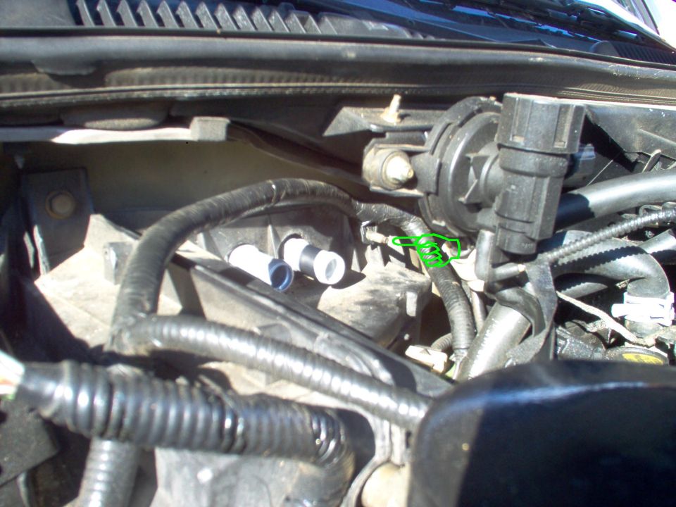 I had already disconnected 1 hose when the core leaked all my coolant into the ventilation system, so I only had 1 hose, this 1 nut, & 3 connectors on this side to remove.  Behind this harness clip, 11mm nut, & the lip of the outside box (black plastic) is a push-nut that retains the stud to the firewall.  Later in this procedure, the stud can be pulled thru that nut without removing the temperature servo or inside nut by pushing here.