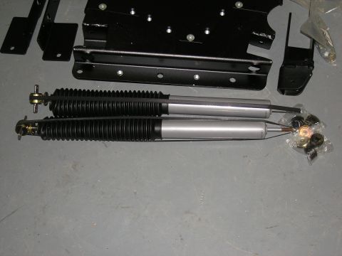 2001 Jeep Wrangler - New shock absorbers and mounting hardware laid out on a gray surface.