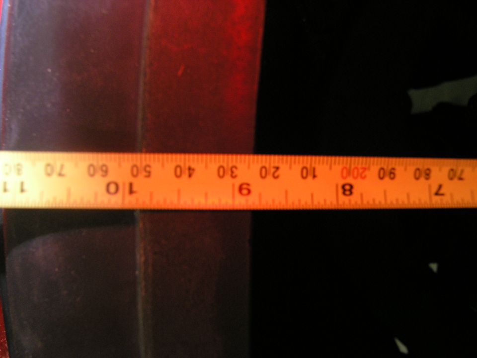 Orange measuring tape with inch and centimeter markings against a dark background. Supermotors.net logo visible