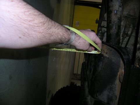 2001 Jeep Wrangler - A hand uses a tape measure to gauge the dimensions of a vehicle component.