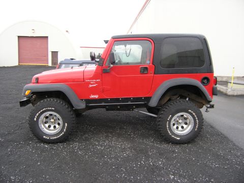 2001 Jeep Wrangler - This red Jeep Wrangler is shown from the side, its off-road tires and hardtop.
